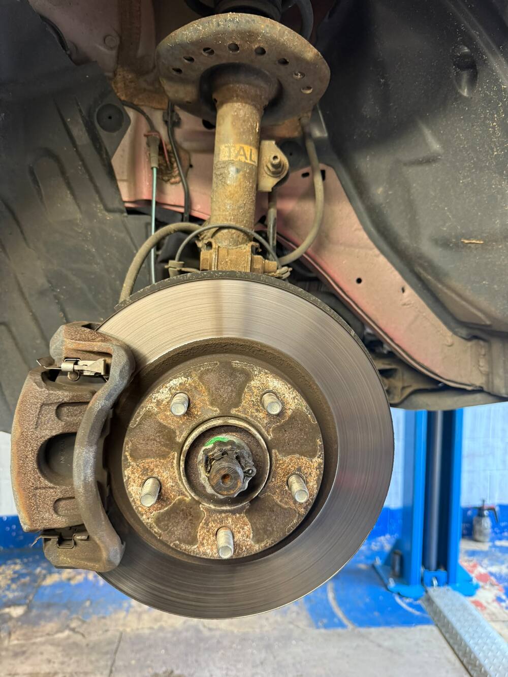 Worn front brake disc and pads before replacement at Pam's MOT Centre in Bletchley